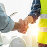 Contractor. construction worker team hands shaking after plan project contract on workplace desk in meeting room office at construction site, contractor, engineering, partnership, construction concept